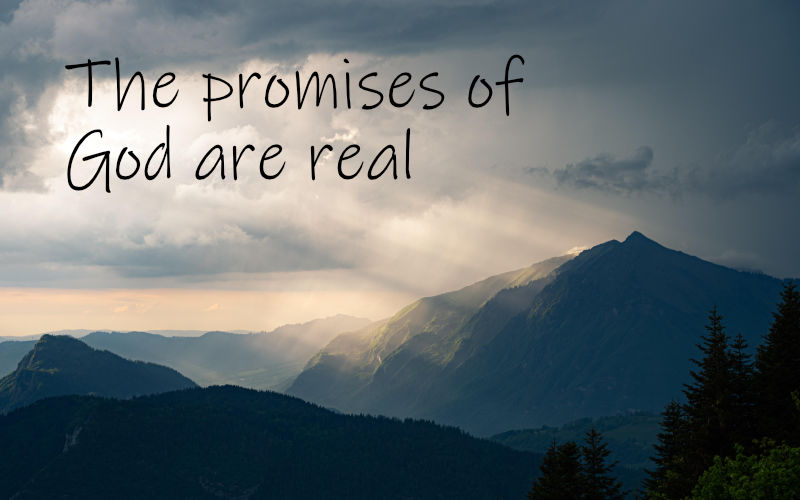 Majestic mountains with sunrays pushing through the clouds. Text says, The promises of God are real