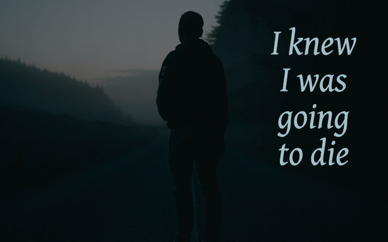 man standing alone on dark road.